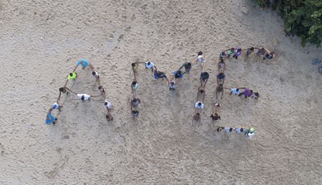 Sigle de l’AME retracé sur la plage avec les élèves